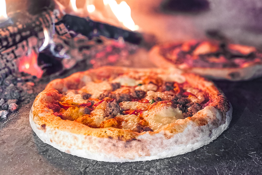 Pizza cooking in wood-fired oven